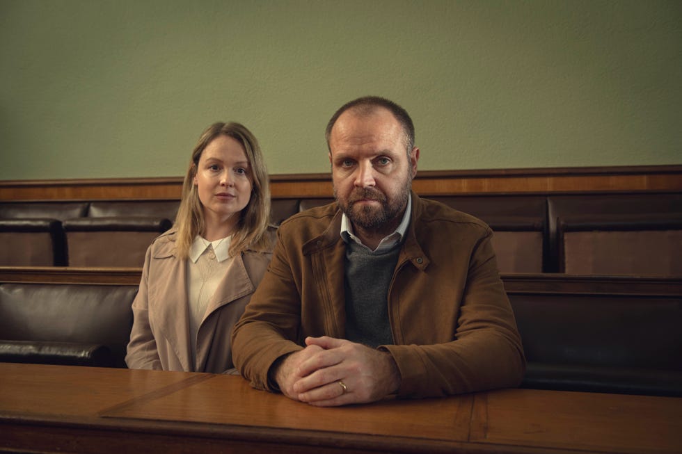 a couple seated in a courtroom setting