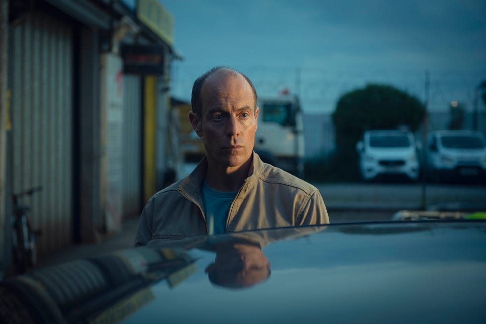 a person standing in front of a vehicle with a blurred background