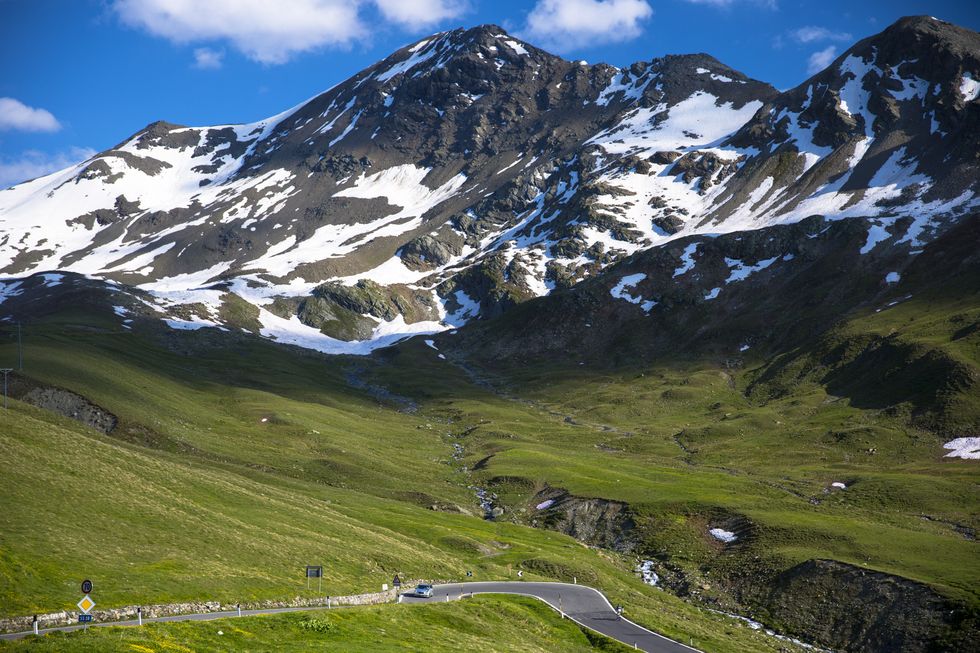 car and cyclist on stelvio pass in the alps, italy
