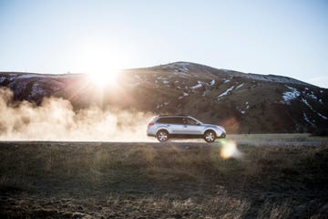 car kicking up dust on dirt road