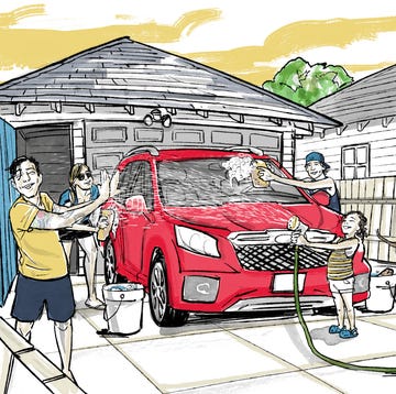 a family takes delight in washing their red family vehicle