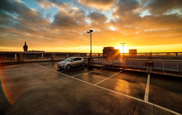 car parked in parking lot against cloudy sky