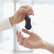 car salesperson handing keys to customer who got a car loan after bankruptcy