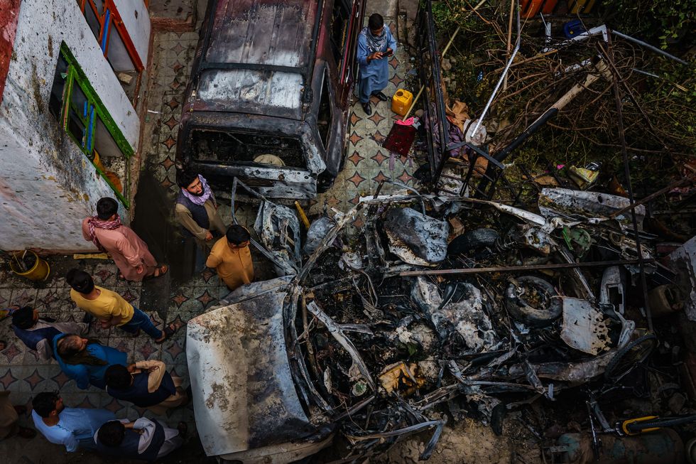 kabul, afghanistan    august 30, 2021 relatives and neighbors of the ahmadi family gathered around the incinerated husk of a vehicle targeted and hit earlier sunday afternoon by an american drone strike, in kabul, afghanistan, monday, aug 30, 2021 marcus yam  los angeles times