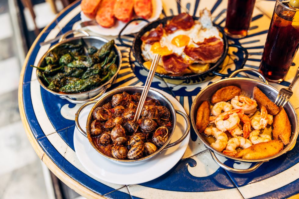 caracoles snails, shrimps with garlic and padron peppers served in spanish tapas restaurant, barcelona, spain