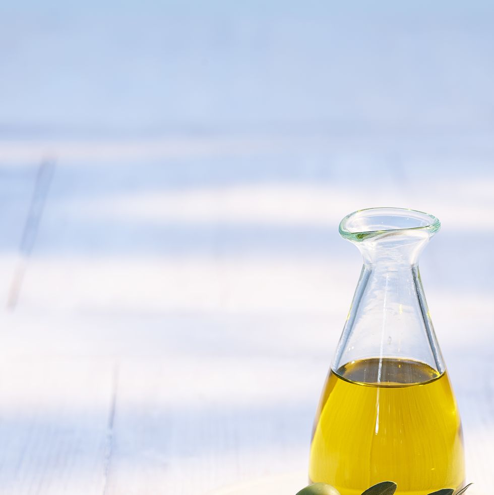 carafe of olive oil on wooden coaster