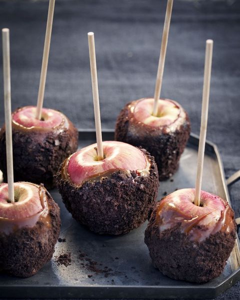 coated caramel apples on black tray with sticks
