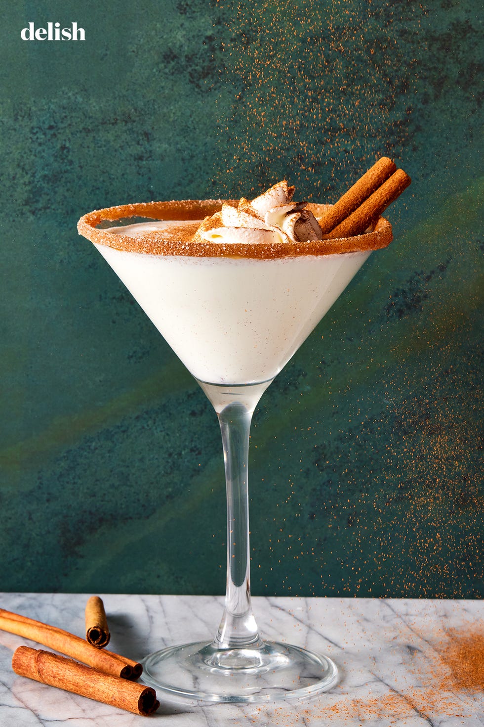 caramel snickerdoodle martini with a caramel rim, whipped cream and cinnamon