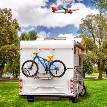 caravan van with bicycle on lawn in park