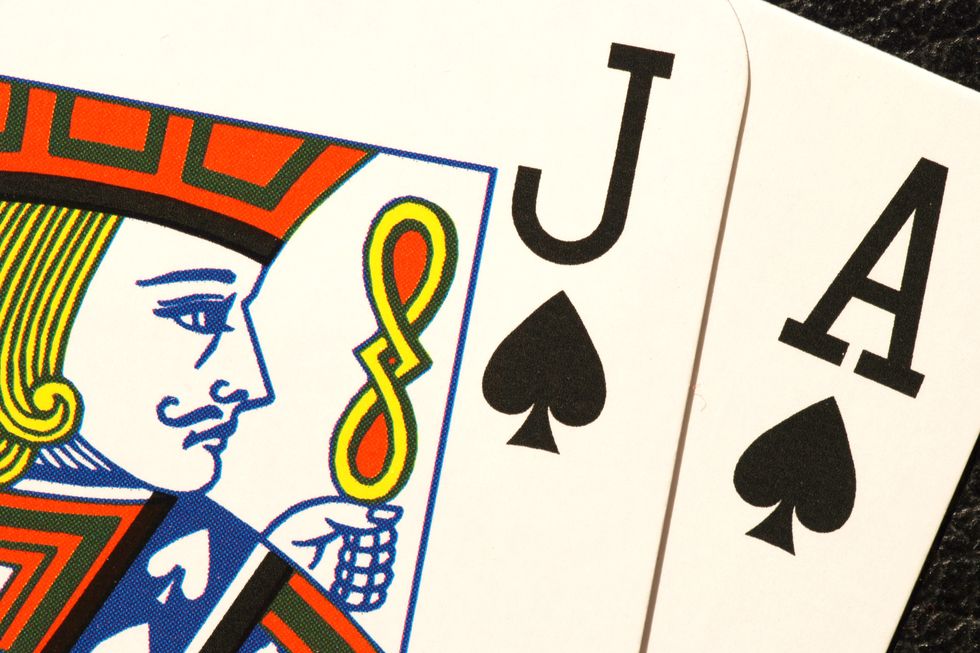 close up of a jack and ace of spades playing cards, the head and shoulder of the jack is visible with the ace behind it