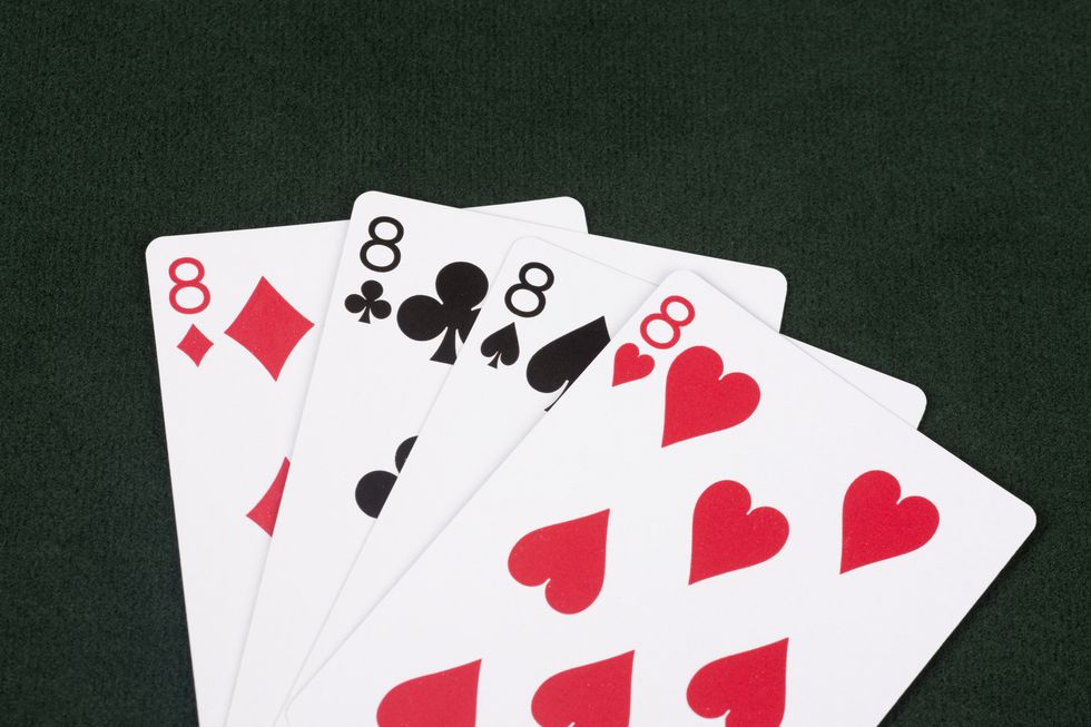 the four eights from a card deck, fanned out against a black background