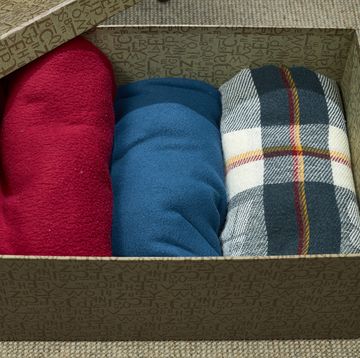 cardboard box with three blankets of different colors