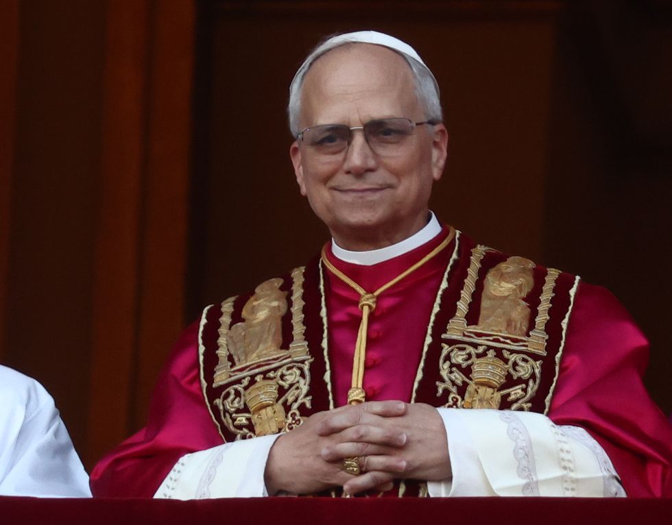man wearing read robes and folding his hands