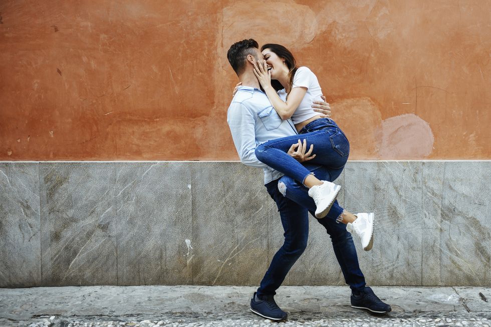 carefree couple in love in front of a wall outdoors
