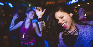 Carefree, enthusiastic young female millennial dancing, partying in nightclub