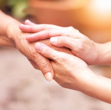 caregiver, carer hand holding elder hand in hospice care philanthropy kindness to disabled concept