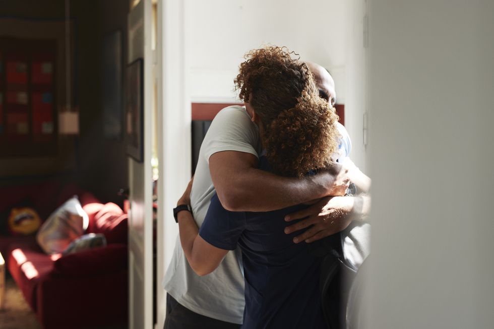 caregiver embracing man at home