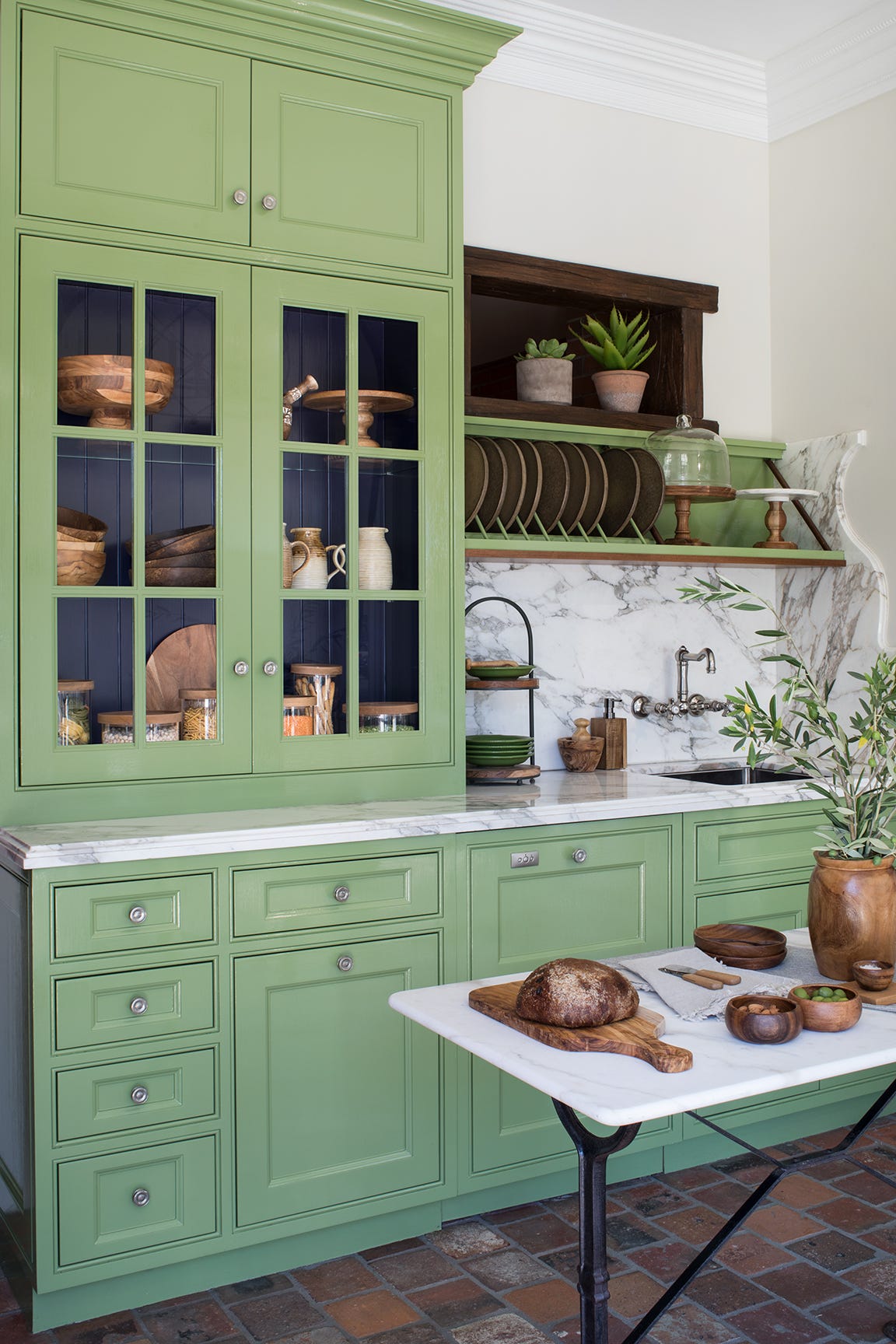 cocina verde con suelo de baldosas de terra cota