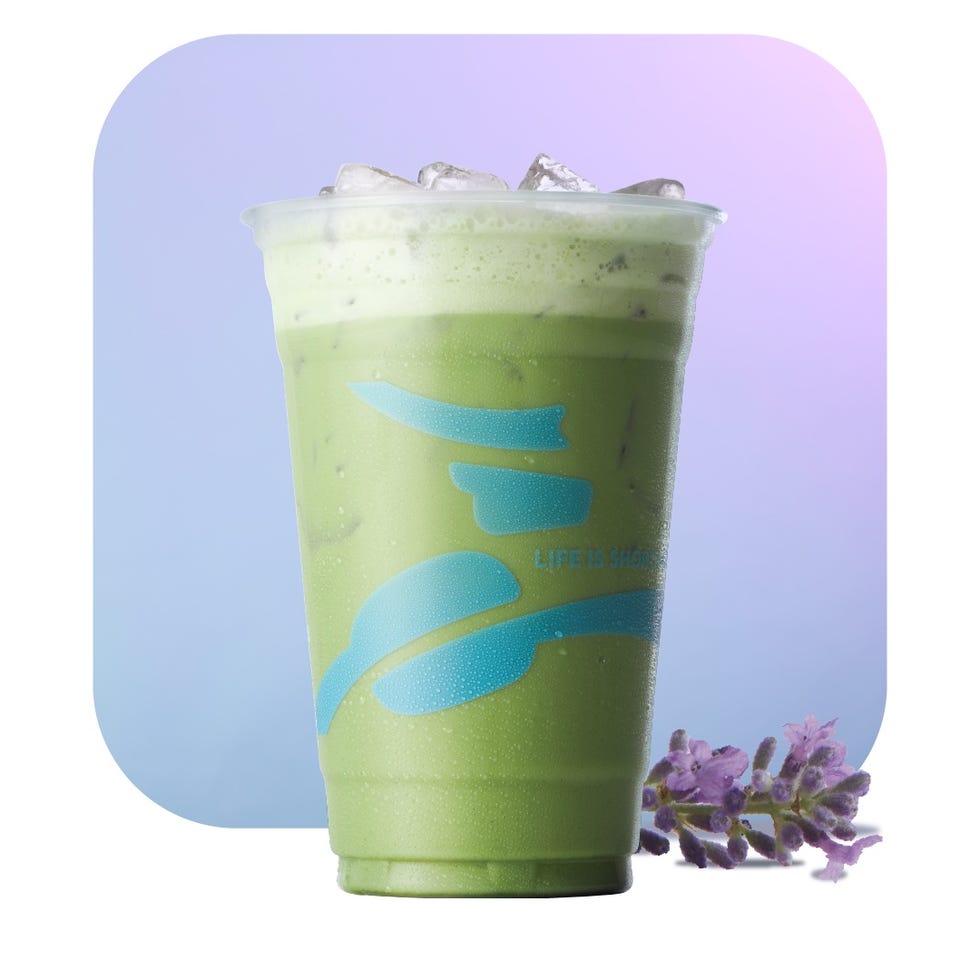 iced matcha beverage in a clear cup with condensation accompanied by lavender flowers