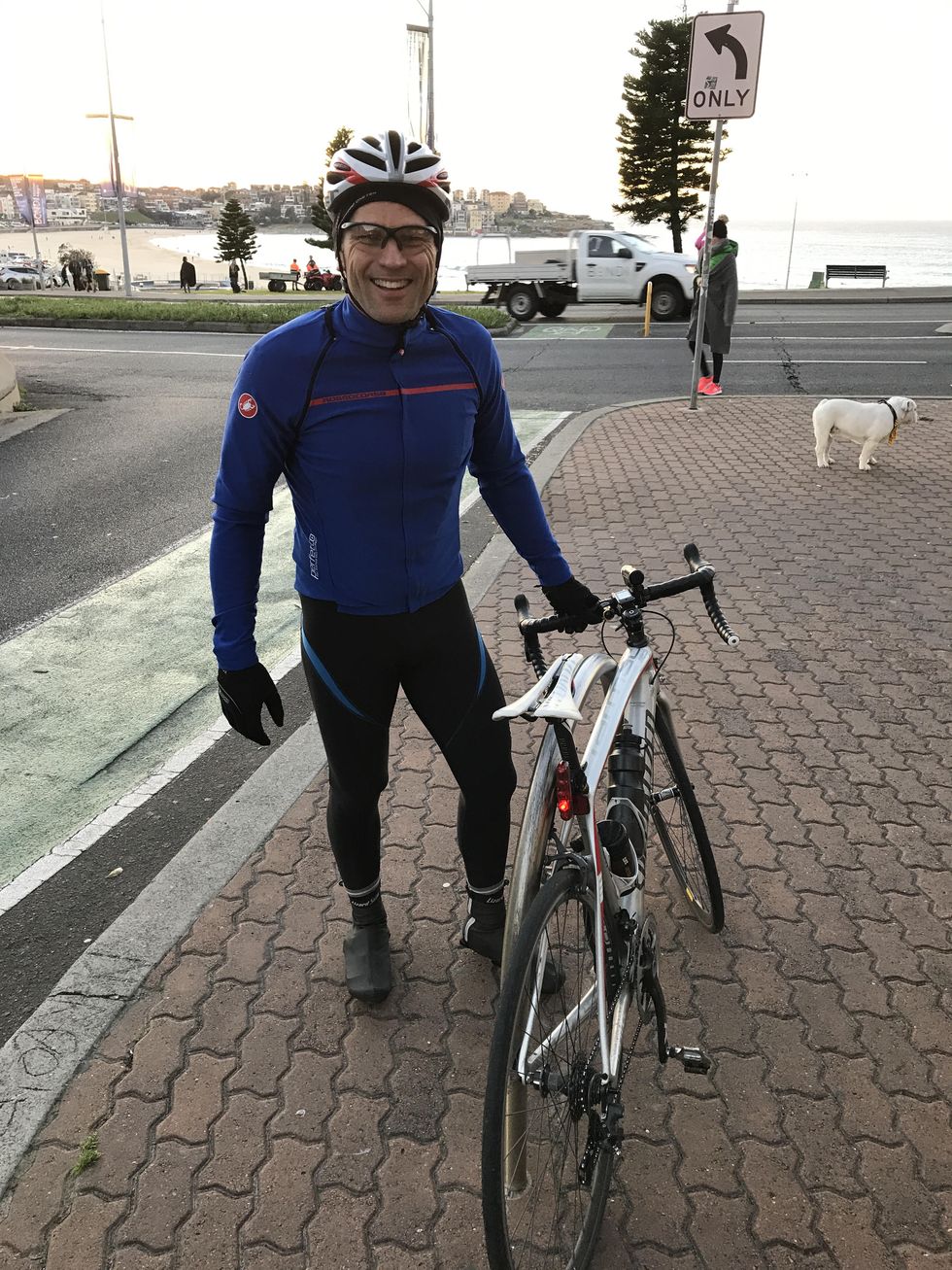 carl matthei in his bike kit standing next to his bike and smiling