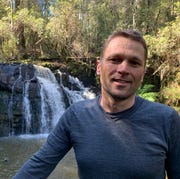 carl matthei standing by a waterfall carl matthei standing by a waterfall