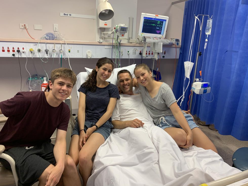 carl matthei awake in bed in the hospital surrounded by family