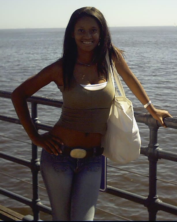 carla barrientos wearing a green tank top, low rise blue jeans, and a belt