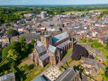 this aerial drone photo shows the large cathedral in carlisle, north west england the church can be found in the town center and is surrounded by a graveyard