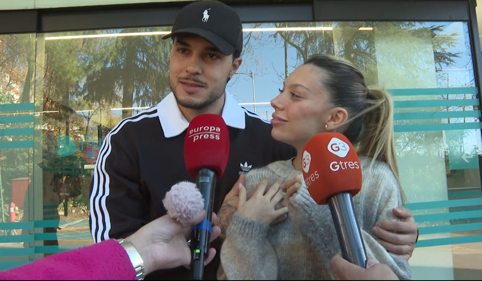 press conference with two individuals being interviewed
