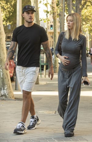 carlo, con pantalon corto y gorra, y alejandra presumiendo de embarazo con un look en color gris