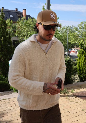 el hijo de mar flores con jersey de punto en blanco, gafas de sol y gorra