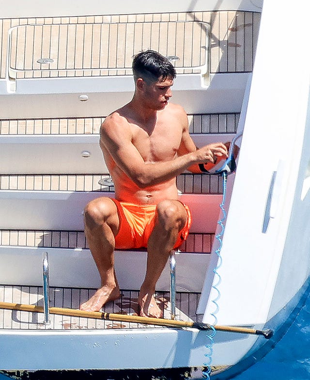 el tenista con un banador en color naranja en un yate en aguas de mallorca