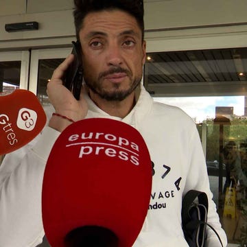 carlos calderon person on a phone call with reporters nearby
