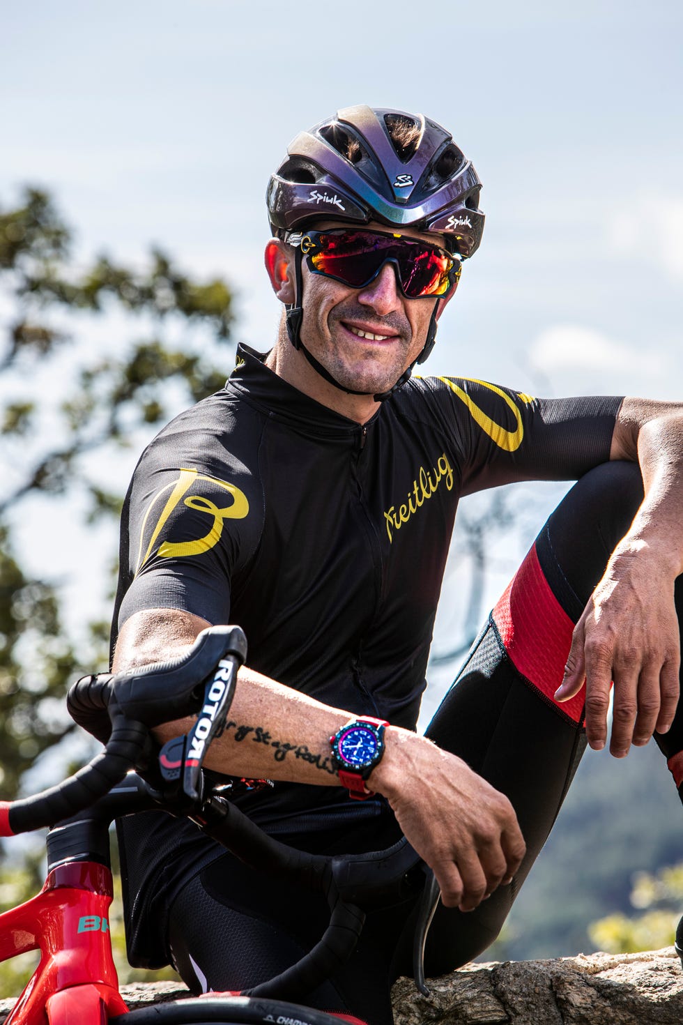 carlos coloma posa con el reloj endurance pro de breitling sobre su bicicleta