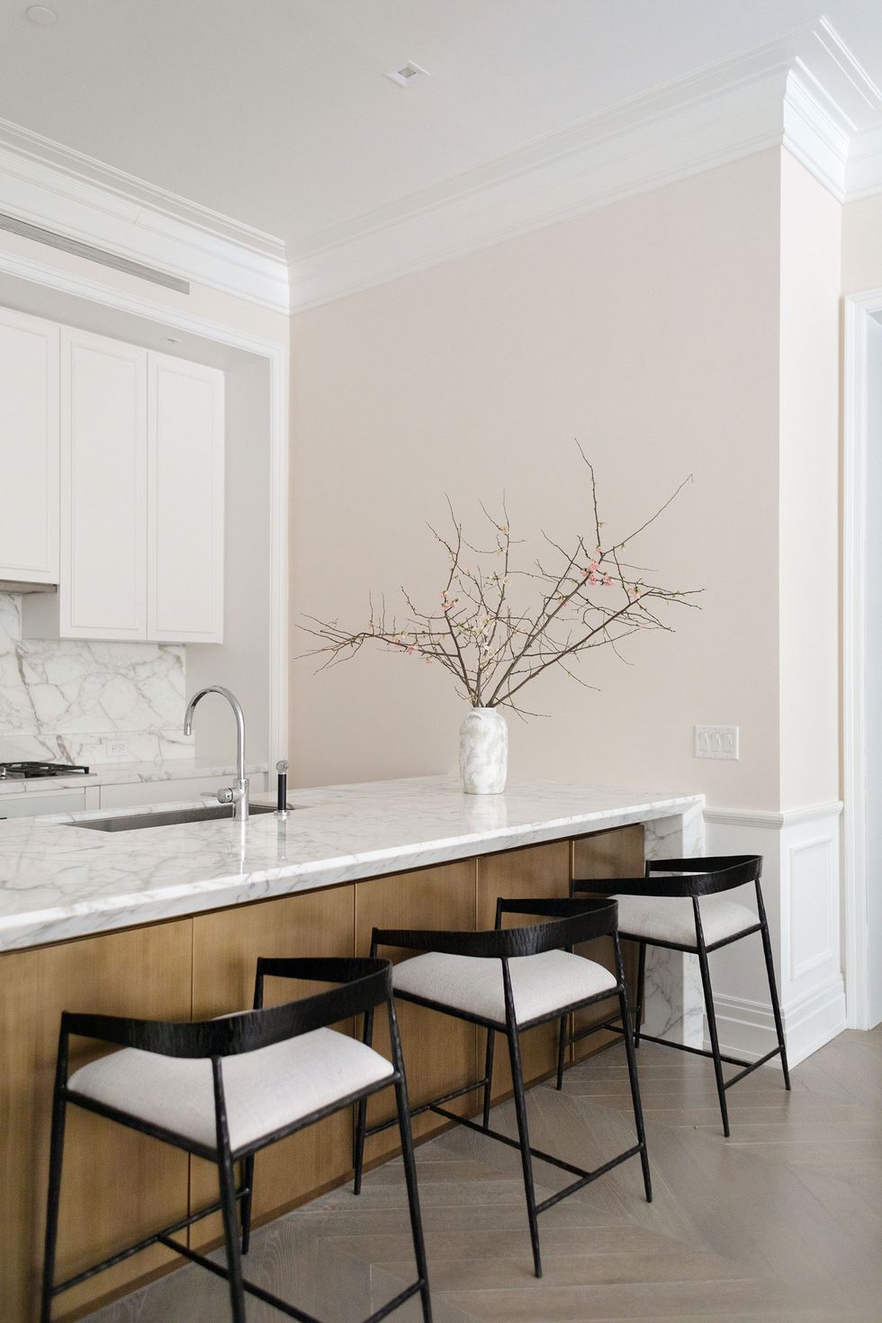 white marble kitchen with black counter stools
