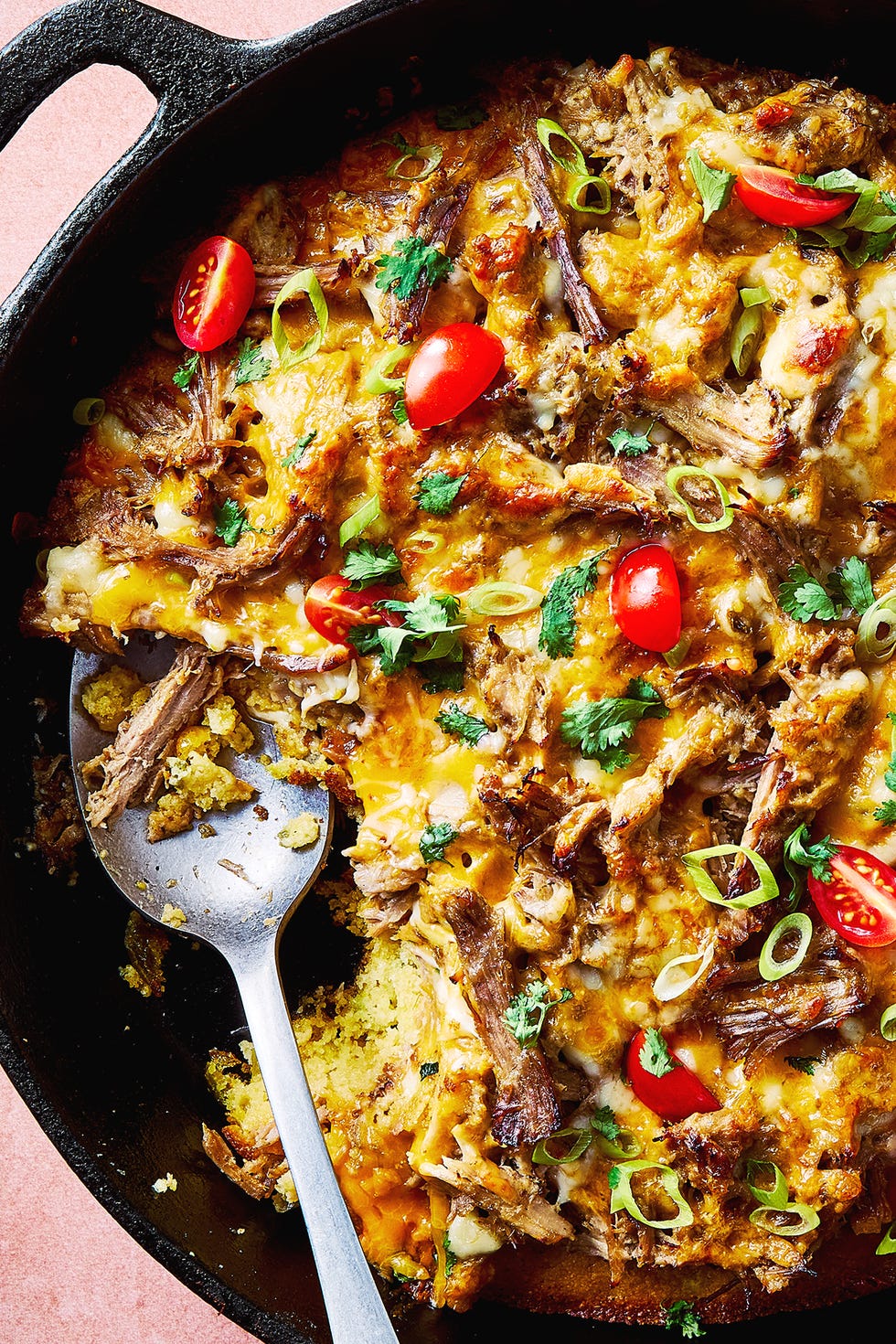 Carnitas Tamale Pie carnitas tamale pie topped with sliced cherry tomatoes, sliced scallions, and chopped cilantro