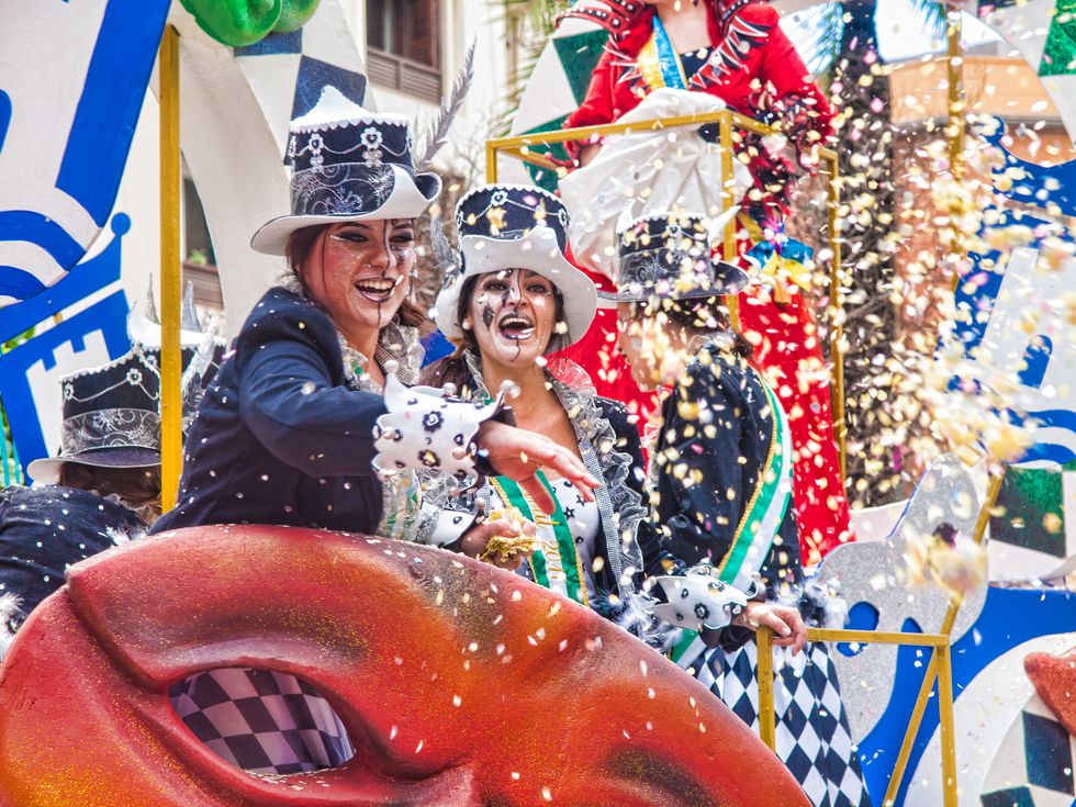 algeciras cheerful laughing carnival participants throw confetti during the parade of the carnival in the street  in algeciras, cadiz, andalusia