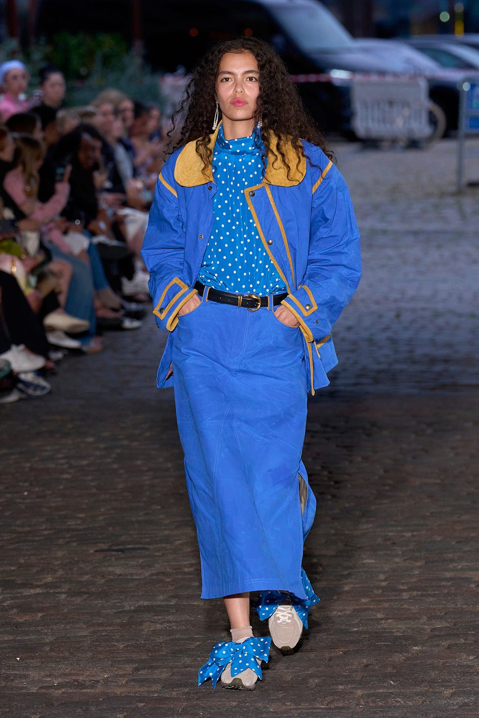 een model loopt op de catwalk in een blauwe look van caro editions