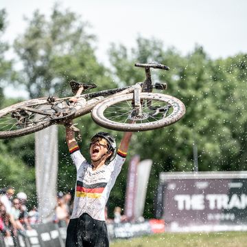 carolin schiff holding up a bicycle after winning the traka 2024