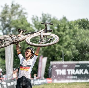 carolin schiff holding up a bicycle after winning the traka 2024