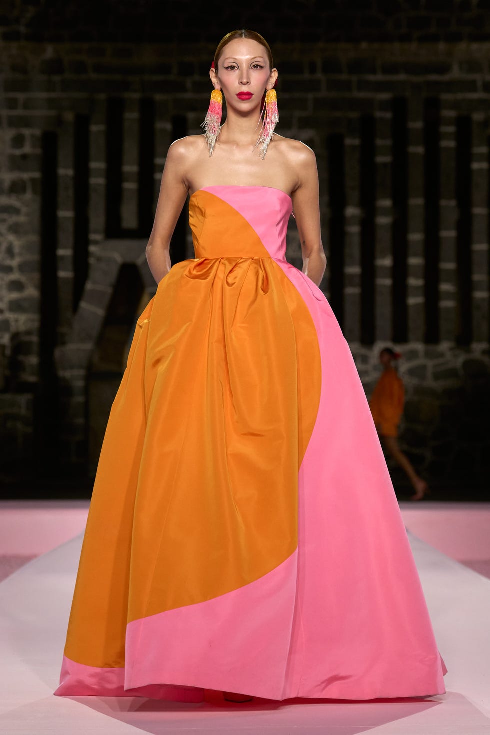 Runway model wearing a colorful gown with vibrant color blocking