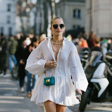 een vrouw in een witte jurk op straat