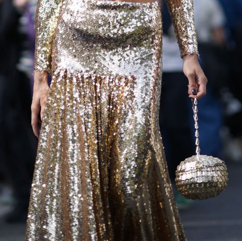 caroline daur wearing a gold sequin skirt and gold metal paco rabanne bag on the street during paris fashion week 2024 in a roundup of the best designer bags 2023