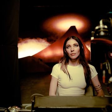 caroline polachek seated on the set of her smoke video