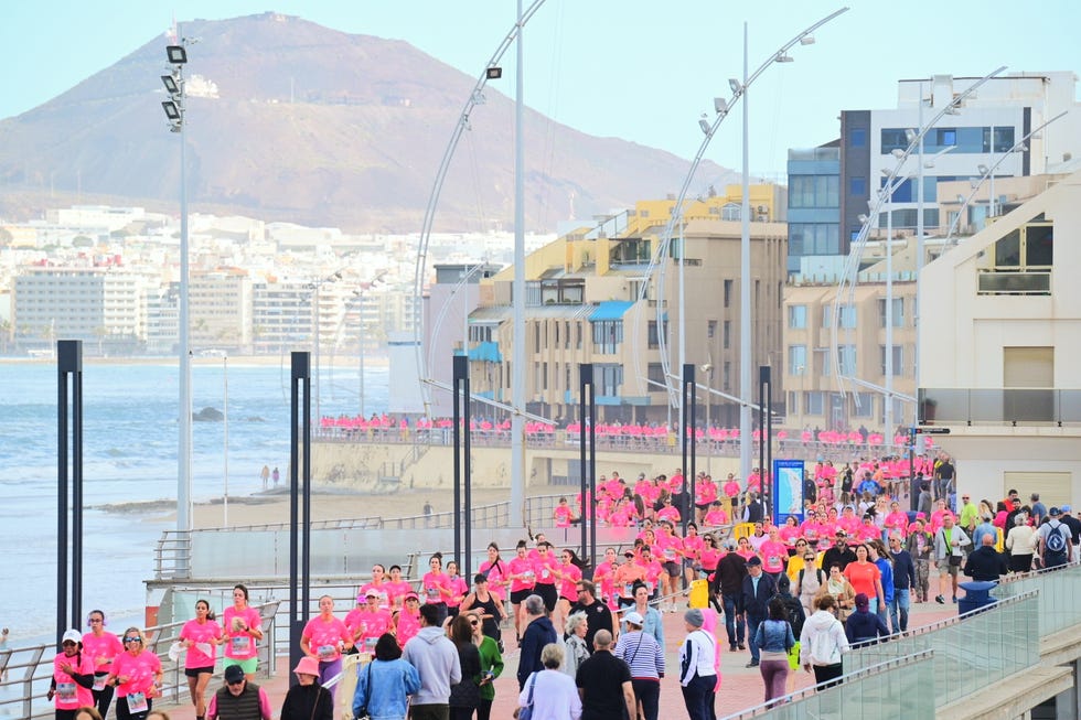 a crowd of people walking on a bridge over water