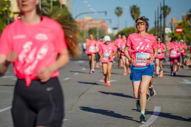 group of runners participating in a race wearing pink shirts