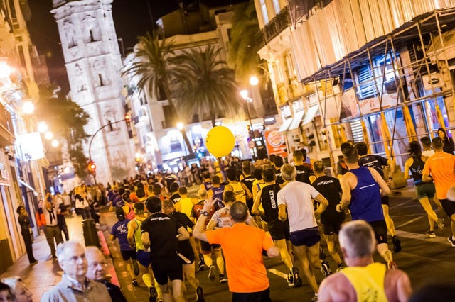 corredores participando en una carrera nocturna por valencia