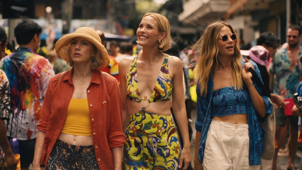 three women walking in a crowded market
