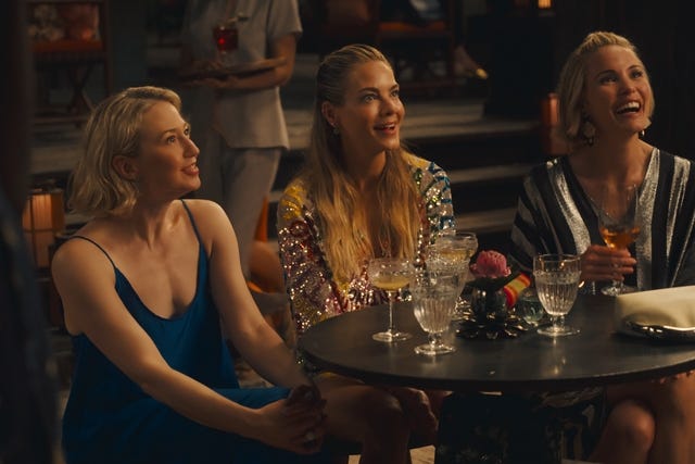 group of women seated at a table in a social setting with drinks