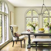 a long table with benches and chairs at the ends in a light filled sunny breakfast room